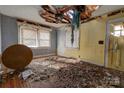 Bedroom in need of repair, with damaged ceiling, debris, and wood floors at 2021 Willis Dr, Shelby, NC 28152