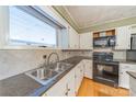 Well-lit kitchen featuring white cabinets, granite countertops, and black appliances at 20329 Efird Rd, Albemarle, NC 28001