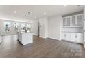 A spacious kitchen features an island with seating and a dining area with modern lighting at 3036 Arbor Ash St # 1022B, Charlotte, NC 28208