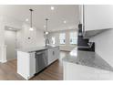 A sleek kitchen showcases an island, modern appliances, white cabinets, and hardwood floors at 3036 Arbor Ash St # 1022B, Charlotte, NC 28208