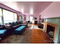 Open-concept living room with fireplace, hardwood floors, and an adjoining dining area at 308 N Hawthorne St, Mount Holly, NC 28120