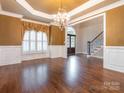 Bright living room with hardwood floors, large windows, and elegant chandelier, perfect for gatherings at 3850 Hounslow Ln, Harrisburg, NC 28075