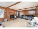 Living room featuring wood paneling, a fireplace, and comfy seating at 6613 Weldon Nw Cir, Concord, NC 28027