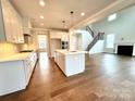 Modern kitchen with white cabinets, large island, and stainless steel appliances at 9811 Ardley Park Way # 30, Mint Hill, NC 28227