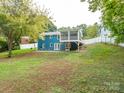 Expansive backyard featuring a screened porch, blue siding and a well-maintained lawn at 1204 Allenbrook Dr, Charlotte, NC 28208