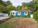 Charming blue house with a landscaped yard and white fence at 1204 Allenbrook Dr, Charlotte, NC 28208