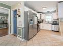 Well-lit kitchen featuring stainless steel appliances, white cabinets and a tile floor at 1204 Allenbrook Dr, Charlotte, NC 28208