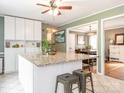 Bright kitchen featuring an island with barstool seating, granite counters and white cabinetry at 1204 Allenbrook Dr, Charlotte, NC 28208