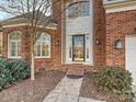 Inviting front entrance with a brick facade and a glass front door at 12434 Kemerton Ln, Huntersville, NC 28078