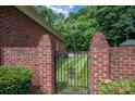 Ornate black gate in brick wall leading to grassy backyard area at 2324 Ryan Conley Ct, Gastonia, NC 28056