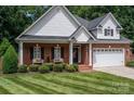 Brick and shingle front elevation of charming home with landscaping and two-car garage at 2324 Ryan Conley Ct, Gastonia, NC 28056