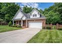 Brick and shingle front elevation of charming home with landscaping and two-car garage at 2324 Ryan Conley Ct, Gastonia, NC 28056