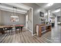 Open dining room featuring stylish wooden floors, rustic wooden table, and modern lighting fixtures at 3155 Pinehills Way, Mount Holly, NC 28120