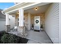 Inviting front porch with brick accents, stylish seating, and a welcoming entrance at 3155 Pinehills Way, Mount Holly, NC 28120