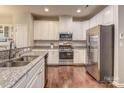 Modern kitchen with white cabinets, granite countertops, and stainless steel appliances at 3203 Morgan Clark Rd, Charlotte, NC 28208