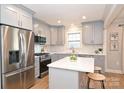 Modern kitchen with stainless steel appliances, gray cabinets, quartz countertops, and island with seating at 532 Scaleybark Rd, Charlotte, NC 28209