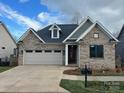 Brick home with gray accents, two-car garage, and neatly landscaped front yard at #77 Silver Trace Ln, Denver, NC 28037