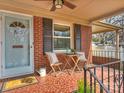 Inviting front porch featuring stylish chairs, table, and a 'hello' door mat with terra cotta tile at 833 Montford Dr, Charlotte, NC 28209