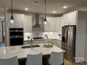 Modern kitchen featuring white cabinets, stainless steel appliances, and a large island at #89 Silver Trace Ln, Denver, NC 28037