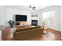 Bright living room with a fireplace, hardwood floors, and a ceiling fan at 13228 Kennerly Dr, Huntersville, NC 28078