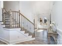 Bright foyer featuring a beautiful staircase with iron spindles and wood treads at 14018 Promenade Dr, Huntersville, NC 28078
