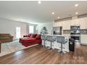Open-concept living room with hardwood floors and a comfortable red sectional sofa at 14041 Castle Nook Dr # 75, Charlotte, NC 28273