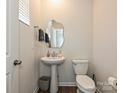 Well-lit powder room showcasing a pedestal sink, toilet, and neutral wall color at 14041 Castle Nook Dr # 75, Charlotte, NC 28273