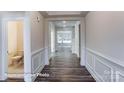 Hallway with dark wood floors, white wainscoting, and views of a nearby half bathroom at 148 Prestwick Way # 21, Mooresville, NC 28115