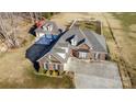 Aerial view of a brick home with an expansive driveway, detached garage, and well-manicured lawn at 219 Society Rd, Statesville, NC 28625