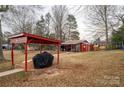 Large backyard with a red shed, playground, and covered patio at 2264 Country Club Rd, Lincolnton, NC 28092