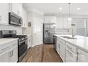 Updated kitchen featuring stainless steel appliances, white cabinetry, and an island with a sink at 3029 Mendenhall St, Indian Trail, NC 28079