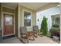 Inviting front porch featuring rocking chairs and view of evergreen tree at 6289 Raven Rock Dr, Denver, NC 28037
