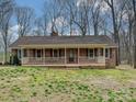 Brick ranch home with welcoming covered porch and spacious yard surrounded by mature trees at 1008 E Sandy Ridge Rd, Monroe, NC 28112