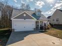 Two-story house with gray siding, white garage door, and landscaping at 102 Lake George Dr, Shelby, NC 28152