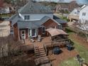 Backyard featuring a spacious wood deck with an umbrella-covered table and chairs perfect for outdoor entertaining at 133 Castaway Trl, Mooresville, NC 28117