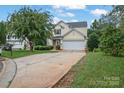 House exterior showcasing a driveway and landscaping at 2111 Bennett Woods Ct, Charlotte, NC 28216