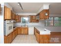 L-shaped kitchen with wood cabinets and appliances at 218 Kingsway Cir, Charlotte, NC 28214