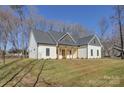 White farmhouse exterior with a gray roof and wooden porch columns at 2712 Yellow Bell Way, Monroe, NC 28112