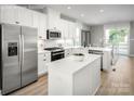 Open concept kitchen with white cabinets, stainless steel appliances, and breakfast bar at 3608 Masonboro St # A, Charlotte, NC 28206