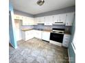 Bright kitchen with white cabinets, tile floor, and standard appliances at 4663 Old Lantern Way, Charlotte, NC 28212