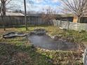 Landscaped backyard with pond, wooden fence, and a swing at 535 Springs East Rd, Lincolnton, NC 28092