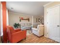 Living room featuring light beige sofas and orange accent chair at 5767 Dove Point Dr, Concord, NC 28025