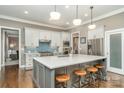 Modern kitchen with white cabinets, a large island, and hardwood floors at 9929 Allyson Park Dr, Charlotte, NC 28277