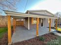 Charming single-Gathering home with gray shingle siding and a large covered patio with rustic wood columns at 1003 W 4Th Ave, Gastonia, NC 28052