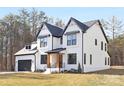 Two-story white brick home with black accents, a gray roof, and a two-car garage at 10517 S Hampton Dr, Charlotte, NC 28227