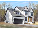 Two-story white brick home with black accents, a gray roof, and a two-car garage at 10517 S Hampton Dr, Charlotte, NC 28227