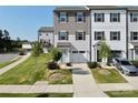 Two-story townhome with gray and white siding, and a two-car garage at 11005 Woodland Creek Way, Charlotte, NC 28262