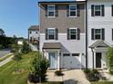 Two-story townhome with gray siding, light blue door, and two-car garage at 11005 Woodland Creek Way, Charlotte, NC 28262