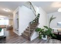 Elegant staircase with wrought-iron railing and neutral carpeting at 11021 Ogden Ln, Charlotte, NC 28278