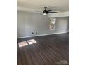 Spacious living room with dark wood floors, a ceiling fan, and lots of natural light at 11124 Northwoods Forest Dr, Charlotte, NC 28214